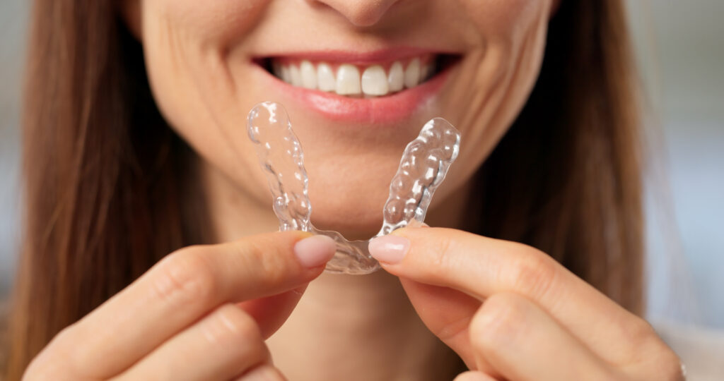 Woman Wearing Transparent Dental Aligner And Night Guard